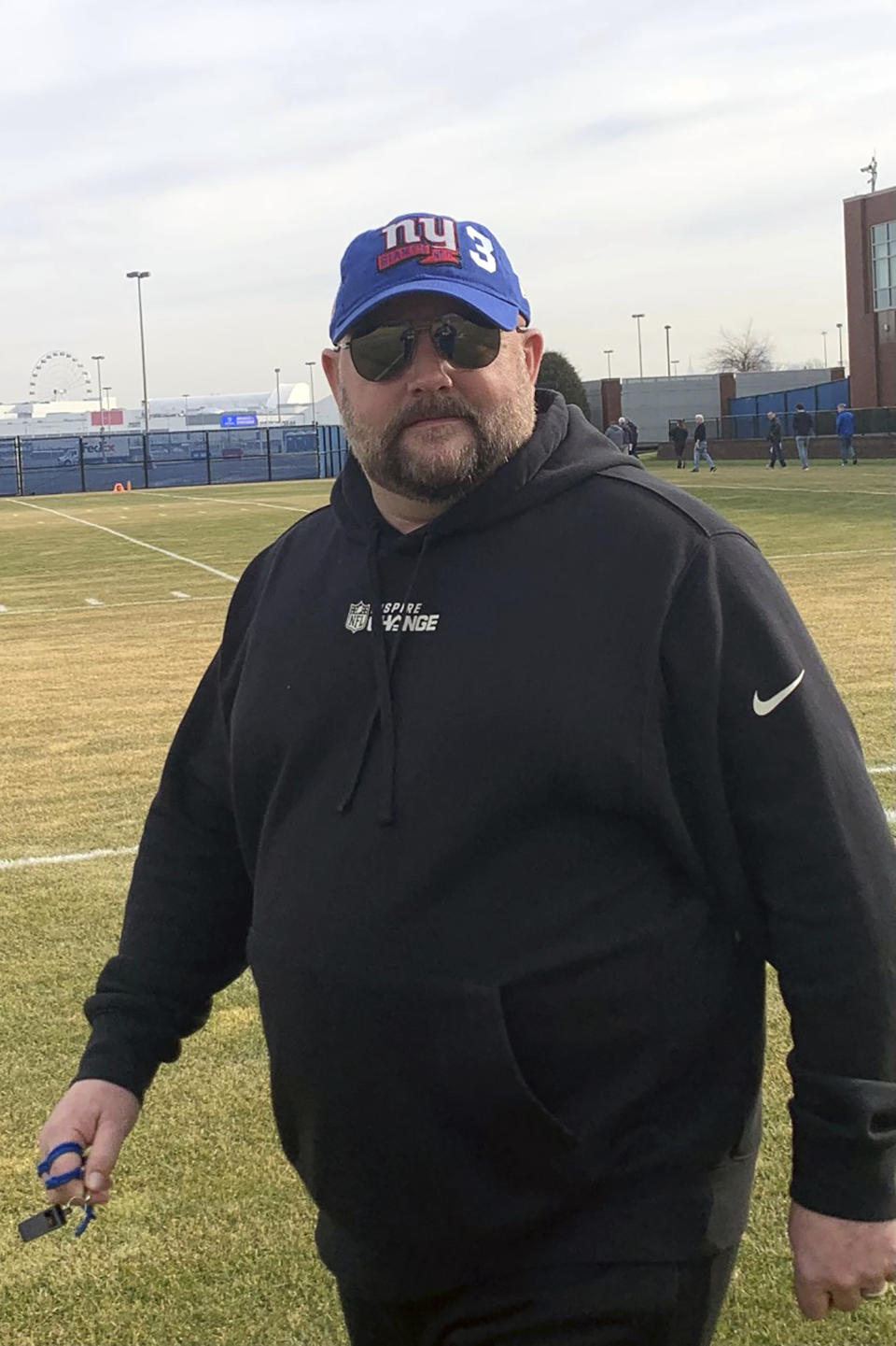In this photo provided by the New York Giants, New York Giants head coach Brian Daboll walks to practice on Wednesday, Jan. 4, 2023 in East Rutherford, N.J., wearing a baseball cap with a Giants emblem and the numeral 3 to honor injured Buffalo Bills safety Damar Hamlin. Daboll was the Bills offensive coordinator for four years before getting the Giants job. Hamlin suffered a cardiac arrest after making a tackle during a nationally televised game in Cincinnati on Monday. (New York Giants via AP)