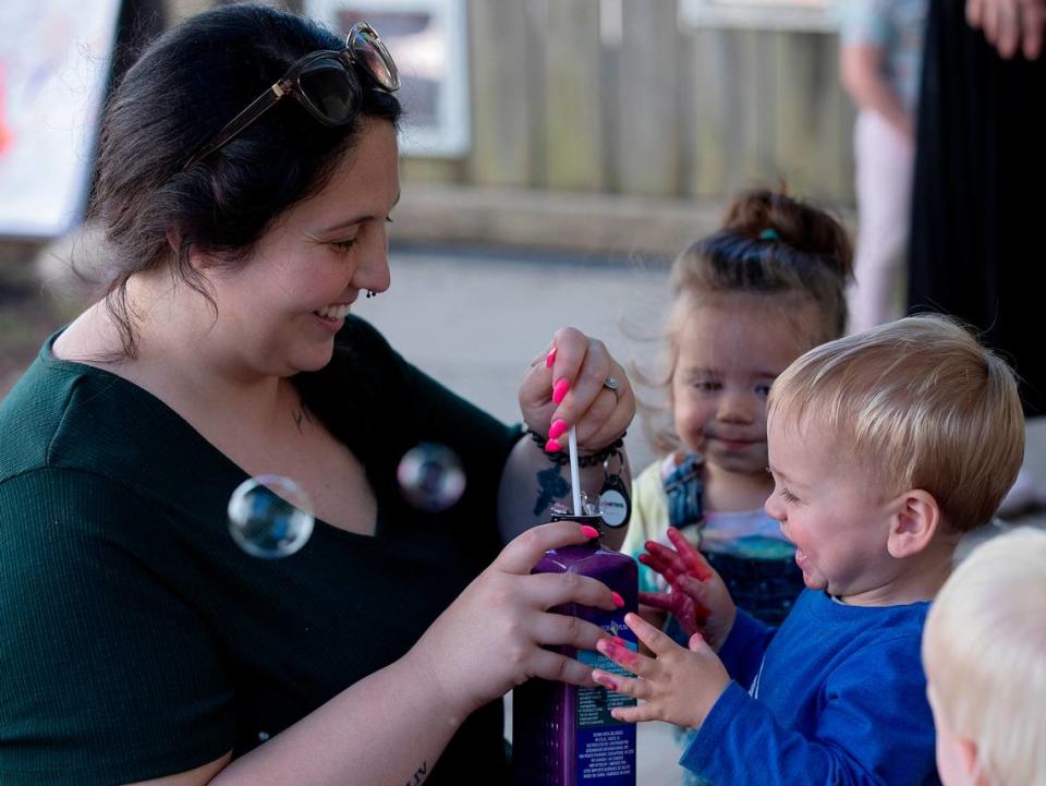 Haley Durham, a teacher at the Little School of Hillsborough, prepares to blow bubbles to the delight of Wells, 1, on Thursday, April 18, 2024, in Hillsborough, N.C.