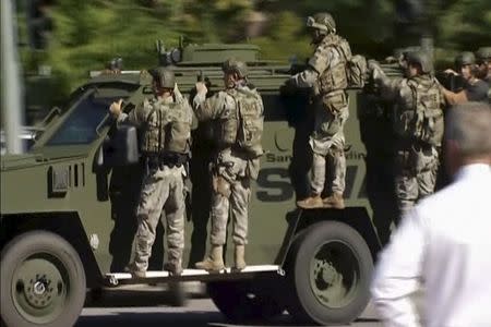 Police SWAT team units on an armored vehicle arrive outside the Inland Regional Center in San Bernardino, California in this still image taken from video December 2, 2015. REUTERS/NBCLA.com/Handout via Reuters