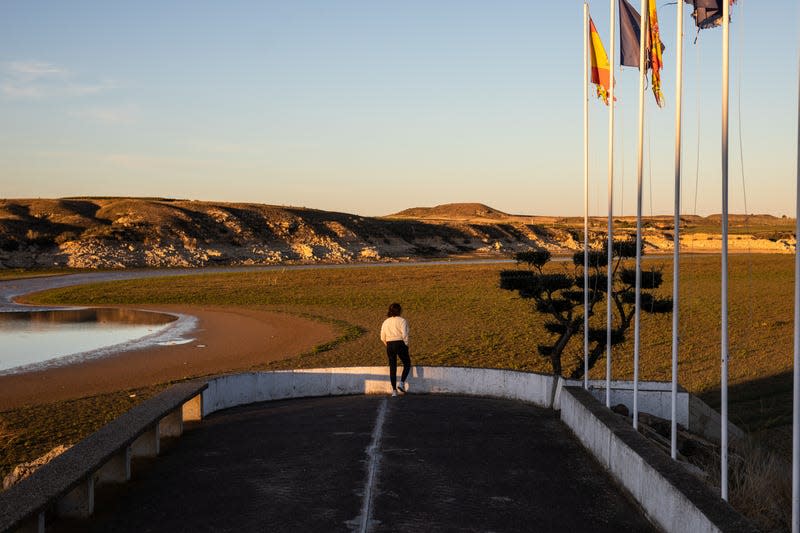 A person observes the low water levels in the reservoir. 