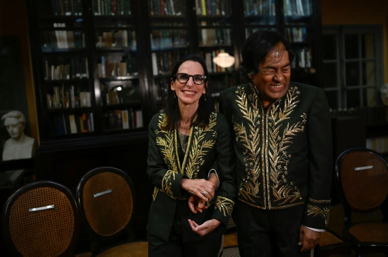 Brazilian Indigenous writer Ailton Krenak (R) and historian Lilia Schwarcz (L) hold hands during the swearing-in ceremony (MAURO PIMENTEL)