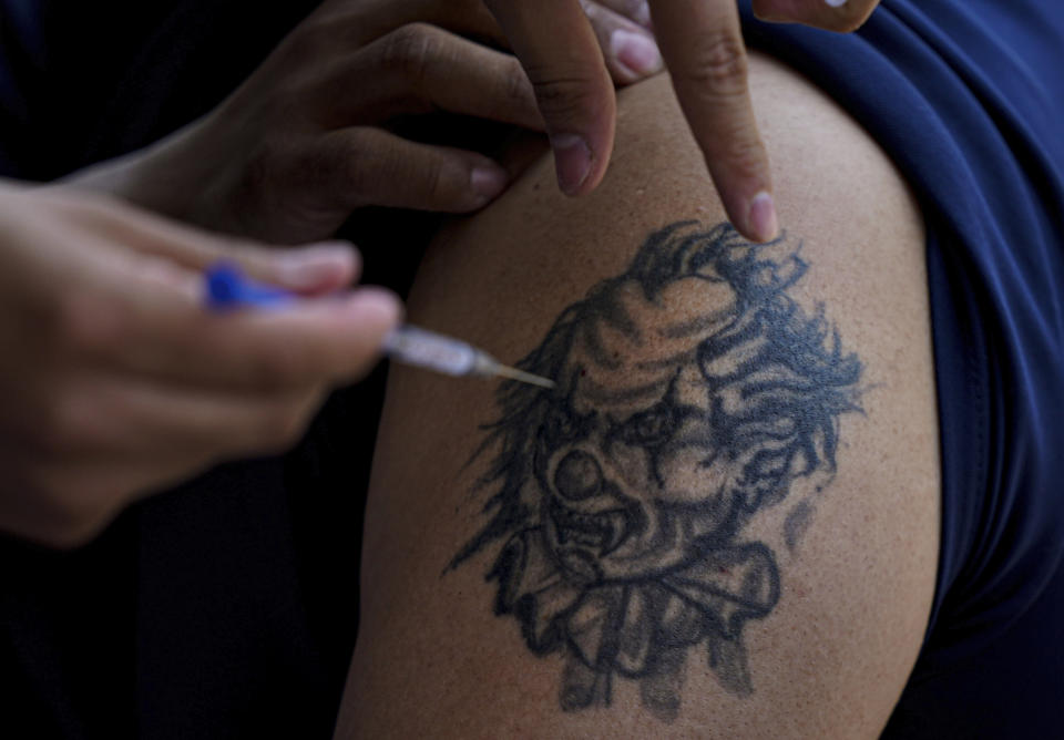 FILE - A youth receives a shot of Russia's Sputnik V coronavirus vaccine during a vaccination drive at University Stadium in Mexico City, July 23, 2021. On Monday, the U.S. will implement a new air travel policy to allow in foreign citizens who have completed a course of a vaccine approved by the Food and Drug Administration or the World Health Organization. That leaves people in Mexico, Hungary, Russia and elsewhere who received the non-approved Russian Sputnik V vaccine or the China-produced CanSino vaccine ineligible to board U.S.-bound flights. (AP Photo/Fernando Llano, File)