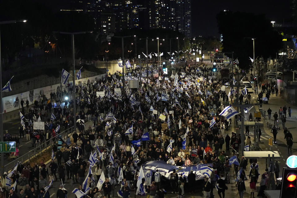 Right-wing Israelis march on a main road as they rally in support of Prime Minister Benjamin Netanyahu's government plans to overhaul the judicial system, in Tel Aviv, Israel, Thursday, March 30, 2023. (AP Photo/Ariel Schalit)