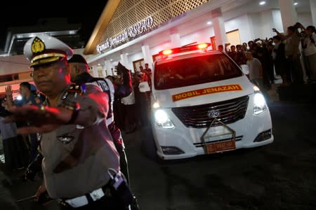 A police officer guards as an ambulance carrying the casket of former Indonesian President B.J. Habibie who passed away this afternoon, leaves Gatot Soebroto Army hospital in Jakarta