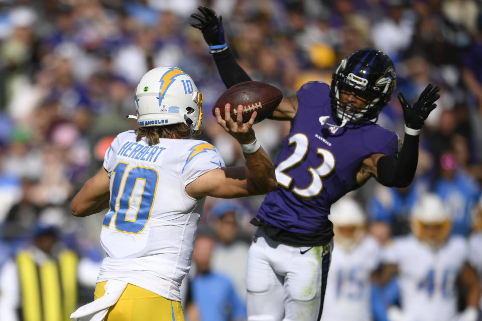 Baltimore Ravens cornerback Anthony Averett (23) applies pressure on Los Angeles Chargers quarterback Justin Herbert (10) during the second half of an NFL football game, Sunday, Oct. 17, 2021, in Baltimore. (AP Photo/Nick Wass)