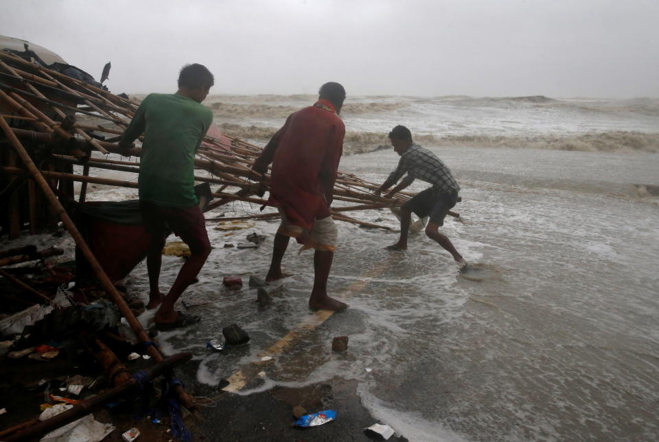 Men remove bamboo rooftop of a stall damaged by heavy winds at a shore ahead of Cyclone Yaas in Bichitrapur in Balasore district in the eastern state of Odisha India, May 26, 2021. REUTERS/Rupak De Chowdhuri