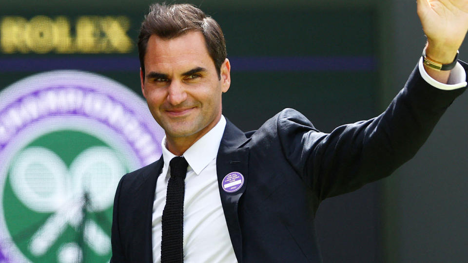 Roger Federer waves to the crowd while appearing on court at Wimbledon.