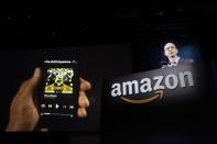 Amazon CEO Jeff Bezos shows off his company's new Fire smartphone at a news conference in Seattle, Washington in this June 18, 2014 file photo. REUTERS/Jason Redmond/Files
