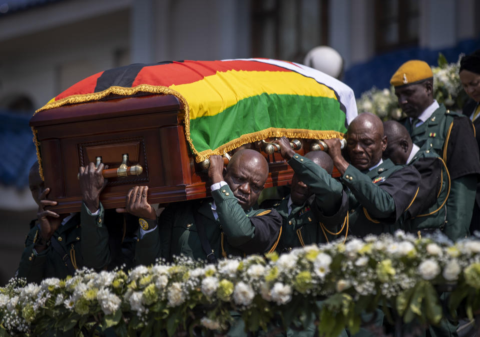 The casket of former president Robert Mugabe is carried by the presidential guard to an air force helicopter for transport to a stadium where it will lie in state, at his official residence in the capital Harare, Zimbabwe Friday, Sept. 13, 2019. The ongoing uncertainty of the burial of Mugabe, who died last week in Singapore at the age of 95, has eclipsed the elaborate plans for Zimbabweans to pay their respects to the former guerrilla leader at several historic sites. (AP Photo/Ben Curtis)
