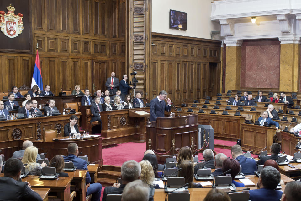 Aleksandar Vucic, the president of Serbia, center, adjusts his glasses as he speaks during a session of Serbia's parliament in Belgrade, Serbia Monday, May 27, 2019. Vucic addressed the Serb parlamentarians during a session devoted to the situation in Kosovo, which declared independence from Serbia in 2008. (AP Photo/Marko Drobnjakovic)