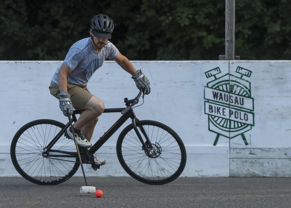 Trevor Williams controls the ball during a game of bike polo on Aug. 11 at Riverside Park in Wausau. The Wausau Bike Polo Club meets on Thursdays and Sundays and invites anyone in the community to come try the sport.