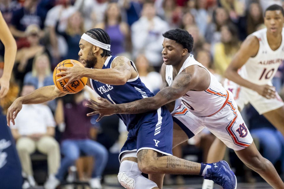 Auburn guard K.D. Johnson (0) reaches for a steal against Yale guard Eze Dike (1) during the first half of an NCAA college basketball game, Saturday, Dec. 4, 2021, in Auburn, Ala. (AP Photo/Vasha Hunt)