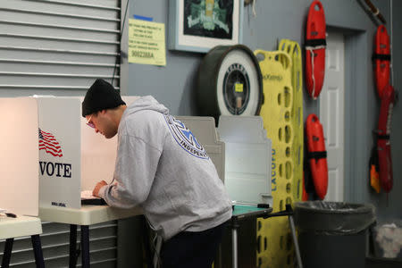 A man votes in the primary election in a polling booth next to lifeguard floats at a polling station in Venice, Los Angeles, California, U.S. June 5, 2018. REUTERS/Lucy Nicholson