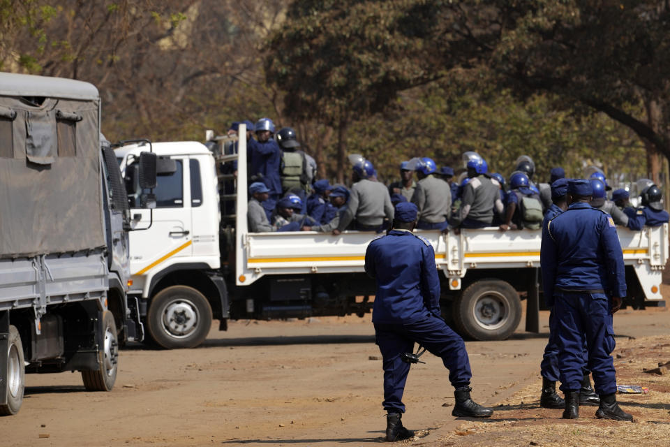 Armed riot police prepare to be deployed on the streets of Harare, Zimbabwe, Friday, Aug. 25, 2023. Hordes of police officers armed with batons, teargas canisters and some with guns were seen next to the result centre as Zimbabweans anxiously waited for the outcome of general elections after polls closed on Thursday and authorities tightened security around the results centre. (AP Photo/Tsvangirayi Mukwazhi)