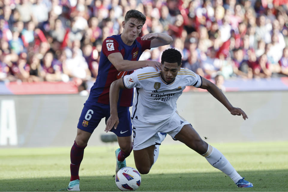 Gavi del Barcelona, izquierda, disputa el balón con Jude Bellingham del Real Madrid durante el partido de fútbol de La Liga entre el Barcelona y el Real Madrid en el Estadio Olímpico de Barcelona, España, el sábado 28 de octubre de 2023. (AP/Joan Monfort)