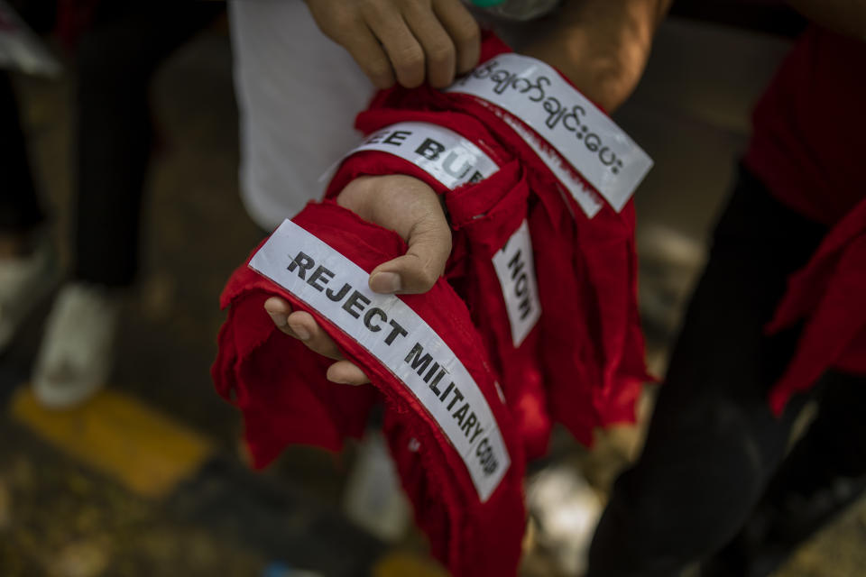 A Chin refugee from Myanmar distributes forehead bands during a protest against military coup in Myanmar, in New Delhi, India, Wednesday, March 3, 2021. (AP Photo/Altaf Qadri)