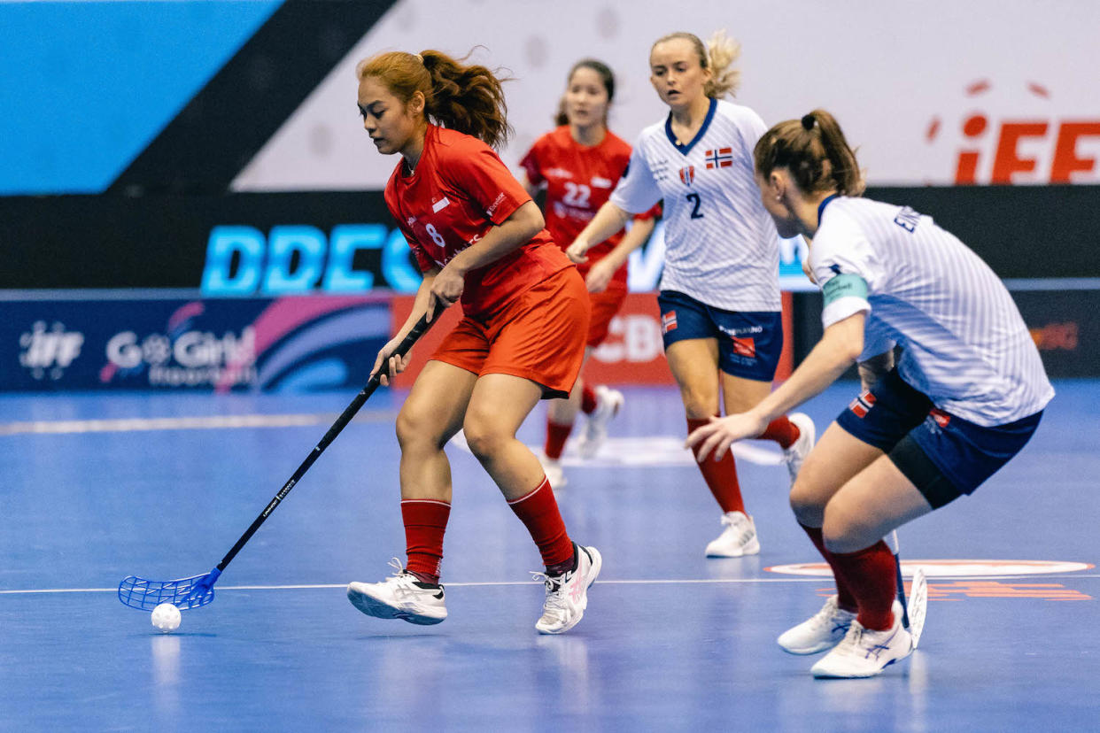 Singapore's Siti Nurhaliza Khairul Anuar (red jersey) in action against Norway in the 11th/12th placing match at the Women's World Floorball Championships at the Singapore Indoor Stadium.