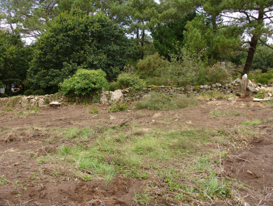 Several large monoliths within a smaller stone wall, as seen at the Carnac site in 2015.