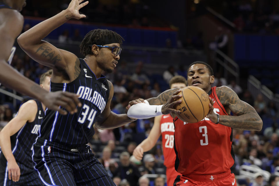 Houston Rockets guard Kevin Porter Jr. (3) is defended by Orlando Magic center Wendell Carter Jr. (34) during the first half of an NBA basketball game, Monday, Nov. 7, 2022, in Orlando, Fla. (AP Photo/Kevin Kolczynski)