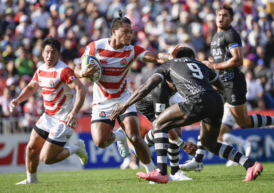 Japan's Lomano Lava Lemekicenter, center, fends off Fiji's Frank Lomani during a Pacific Nations Cup rugby match at Kamaishi Recovery Memorial Stadium in Kamaishi, northern Japan, Saturday, July 27, 2019. Japan took big step forward in Rugby World Cup preparation with a five-try 34-21 win over Fiji in Pacific Nations Cup (Tsuyoshi Ueda/Kyodo News via AP)
