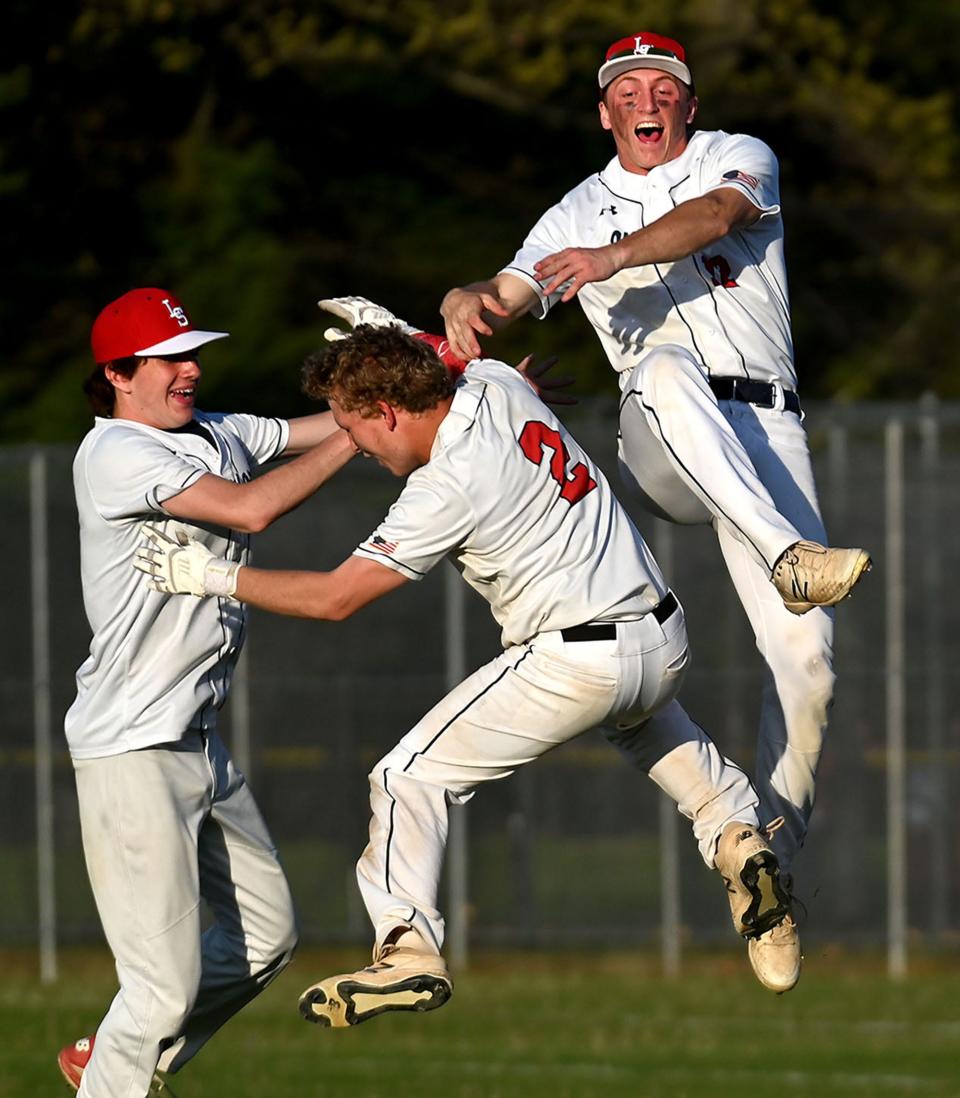 Lincoln-Sudbury's Evan Munuz, center, (2) is mobbed by teammates Bobby Haarde, right, and Jaden McGinty at second base after hitting an RBI double driving in Jake Haarde for the seventh-inning, game-winning run in the Warriors 8-7 win over Bedford at Lincoln-Sudbury on May 12.