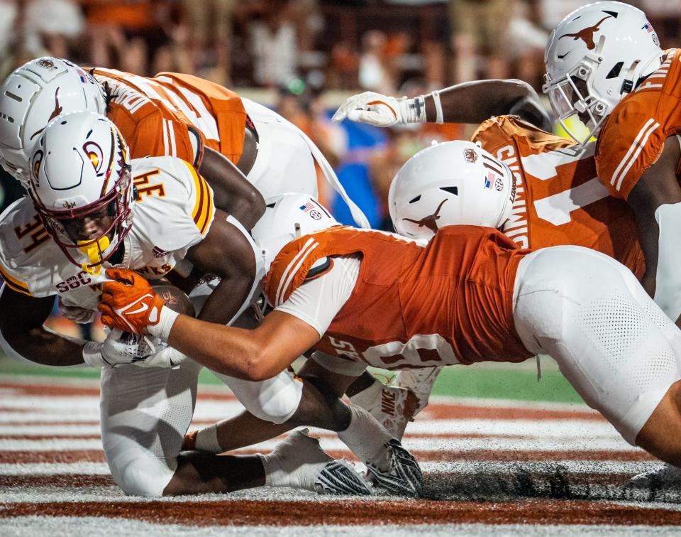 Linebacker Liona Lefau, center, and the Texas defense bring down Louisiana-Monroe running back Ozarrio Smith for a safety in the Longhorns' win Saturday at Royal-Memorial Stadium in Austin. Lefau, a sophomore, had a career game with seven tackles and a sack.