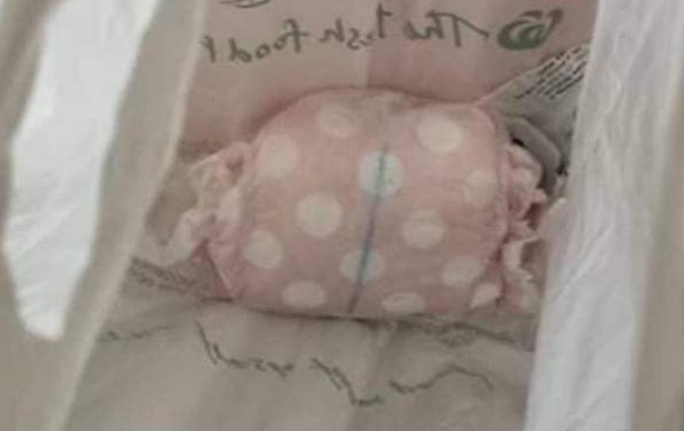 A wet nappy sits in the bottom of a Woolworths plastic bag.