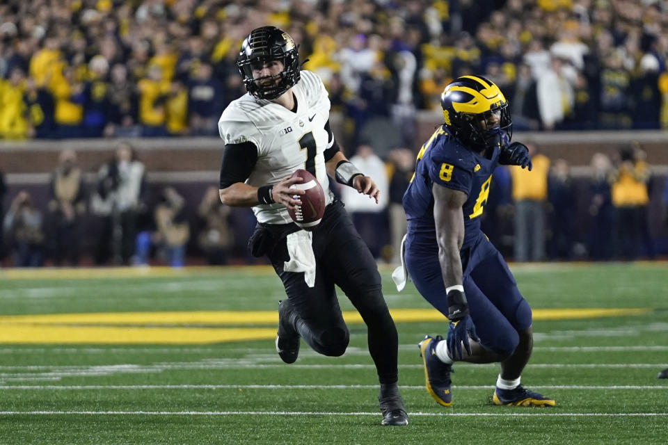 Purdue quarterback Hudson Card (1) scrambles from Michigan defensive end Derrick Moore (8) in the first half of an NCAA college football game in Ann Arbor, Mich., Saturday, Nov. 4, 2023. (AP Photo/Paul Sancya)