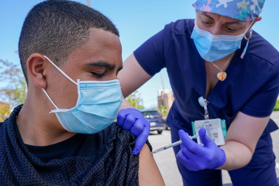 Justin Bishop, 13, receives the first dose of the Pfizer-BioNTech COVID-19 vaccine on May 14, 2021, at the Mount Sinai South Nassau Vaxmobile in Freeport, N.Y.