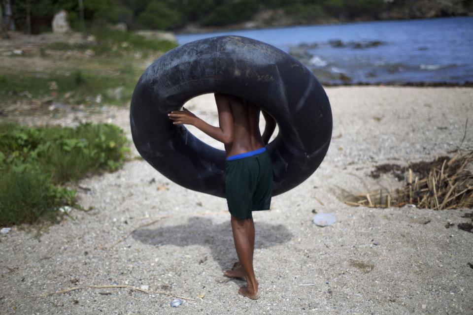 A youth carries a rubber float on the beach in Guama, Cuba, Friday, Aug. 24, 2012. Tropical Storm Isaac strengthened slightly as it spun toward the Dominican Republic and vulnerable Haiti on Friday, threatening to bring punishing rains but unlikely to gain enough steam to strike as a hurricane. Cuba declared a state of alert Friday for six eastern provinces. (AP Photo/Ramon Espinosa)