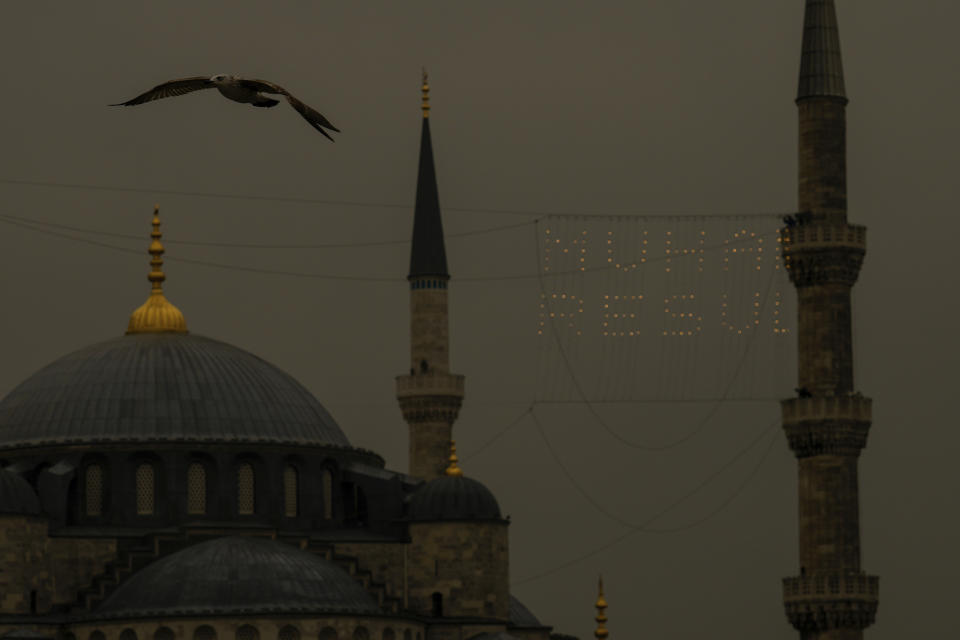 Mahya masters, top right, work in the installation of a lights message at the top of one of the minarets of the Ottoman-era Sultanahmet mosque, or Blue mosque, ahead of the Muslim holy month of Ramadan, in Istanbul, Turkey, Tuesday, March 5, 2024. Mahya is the unique Turkish tradition of stringing religious messages and designs between minarets. (AP Photo/Emrah Gurel)