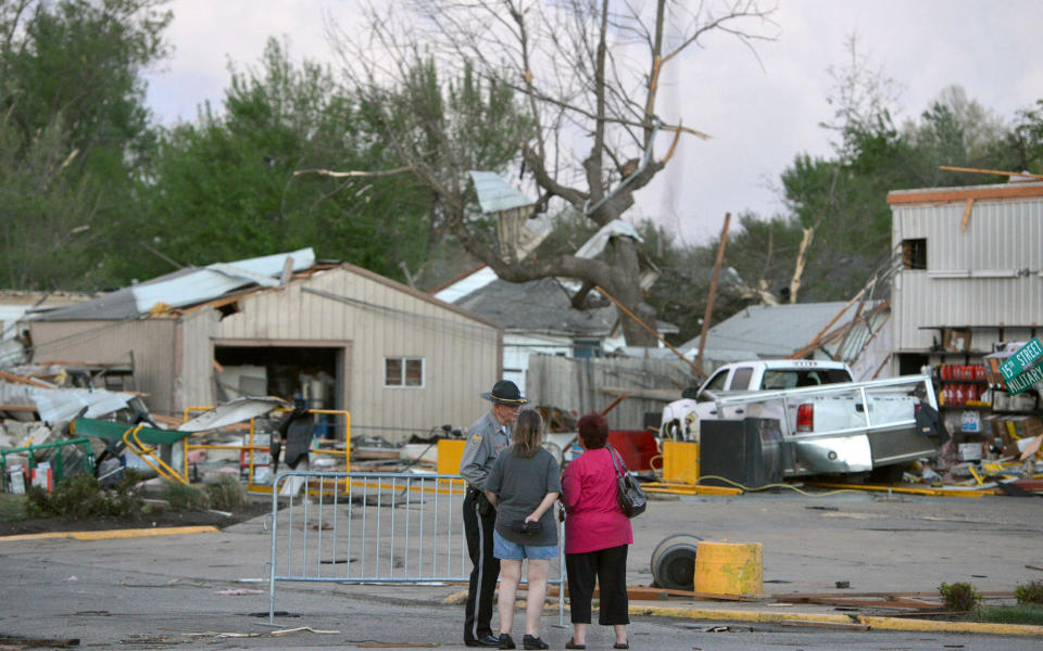 A officer talks to people at 15th and Military following Sunday's tornado in Baxter Springs, Kan., Sunday April 27, 2014. A powerful storm system rumbled through the central and southern United States on Sunday, spawning a massive tornado that carved through Little Rock's northern suburbs and another that hit Oklahoma and Kansas. (AP Photo/The Joplin Globe, Roger Nomer )