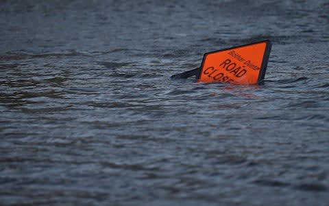 A 'road closed' sign is seen submerged in floodwater during Storm Ophelia in Galway, Ireland - Credit: CLODAGH KILCOYNE/ REUTERS