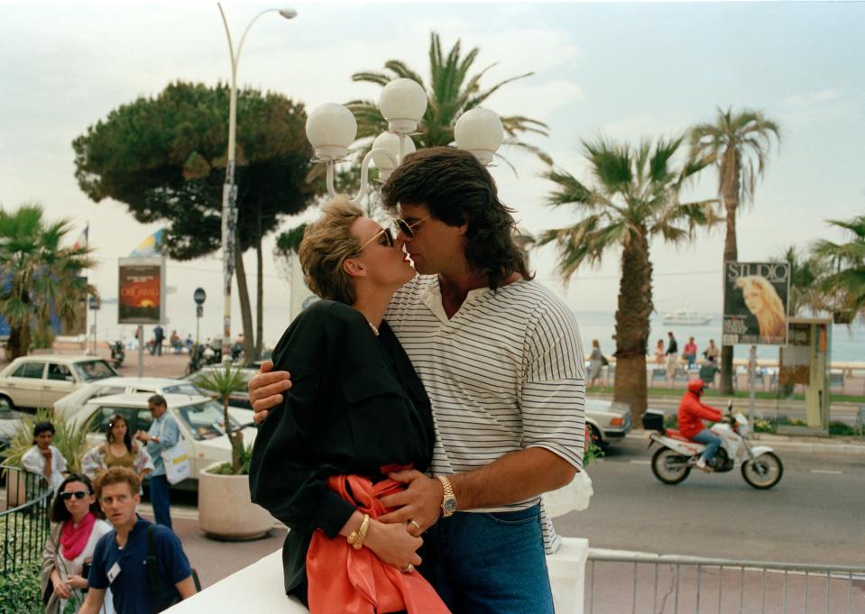 Sylvester Stallone's ex-wife Danish model Brigitte Nielsen kisses her friend U.S. football player Mark Gastineau, as they showed up on the terrace of their hotel in Cannes, France, May 18, 1989, during the International Film Festival.