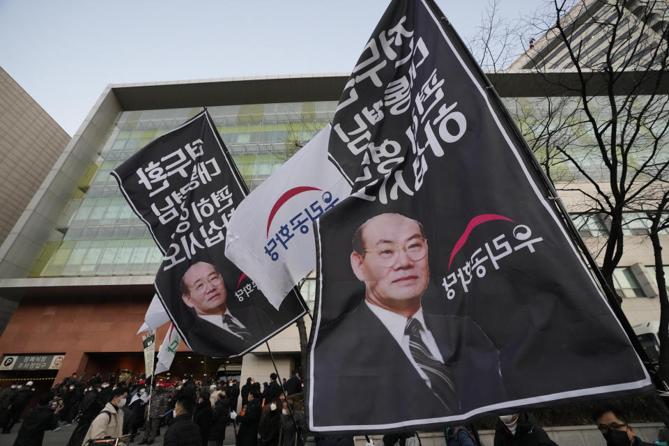 Mourners gather outside a funeral hall of the late former South Korean President Chun Doo-hwan in Seoul, South Korea, Saturday, Nov. 27, 2021. Former South Korean military strongman Chun, who crushed pro-democracy demonstrations in 1980, died on Tuesday. He was 90. The flags read: "President Chun Doo-hwan rests in peace." (AP Photo/Ahn Young-joon)