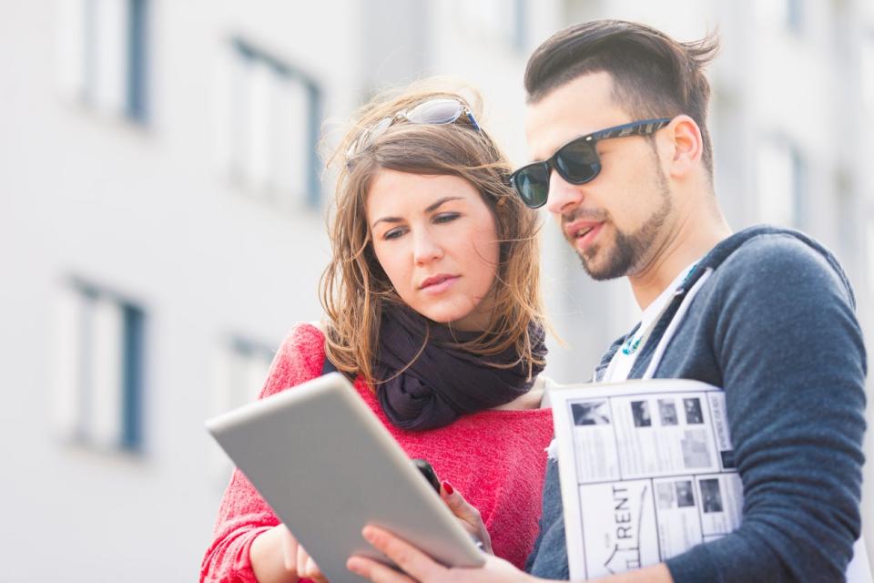 couple checking home listings on iPad