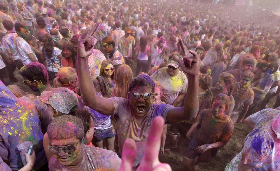 Revelers covered in colored corn starch celebrate during the 2014 Festival of Colors, Holi Celebration at the Krishna Temple Saturday, March 29, 2014, in Spanish Fork, Utah. Nearly 70,000 people are expected to gather starting Saturday at a Sri Sri Radha Krishna Temple in Spanish Fork for the annual two-day festival of colors. Revelers gyrate to music and partake in yoga during the all-day festival, throwing colored corn starch in the air once every hour. The Salt Lake Tribune reports that the large majority of participants are not Hindus, but Mormons. Thousands of students from nearby Brigham Young University come to take part in a festival that is drug and alcohol free. The event stems from a Hindu tradition celebrating the end of winter and the triumph of good over evil. (AP Photo/Rick Bowmer)