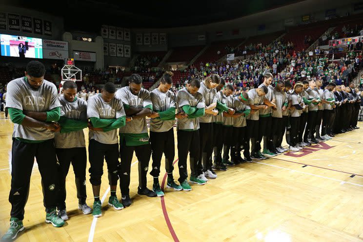 Players and coaches for the Boston Celtics crossed arms and held hands during the National Anthem. (Chris Marion/Getty Images)