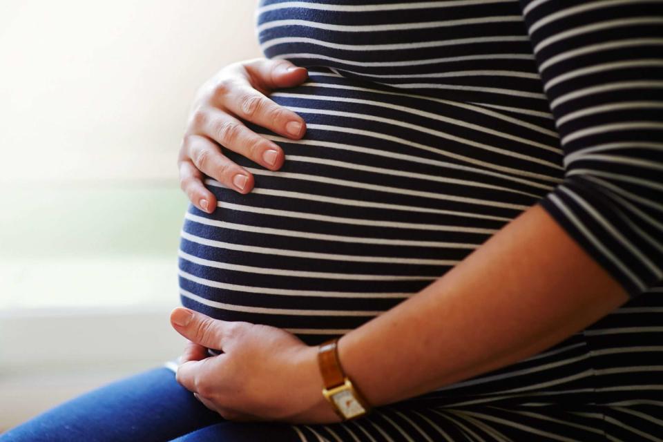 Getty Pregnant woman holding bump