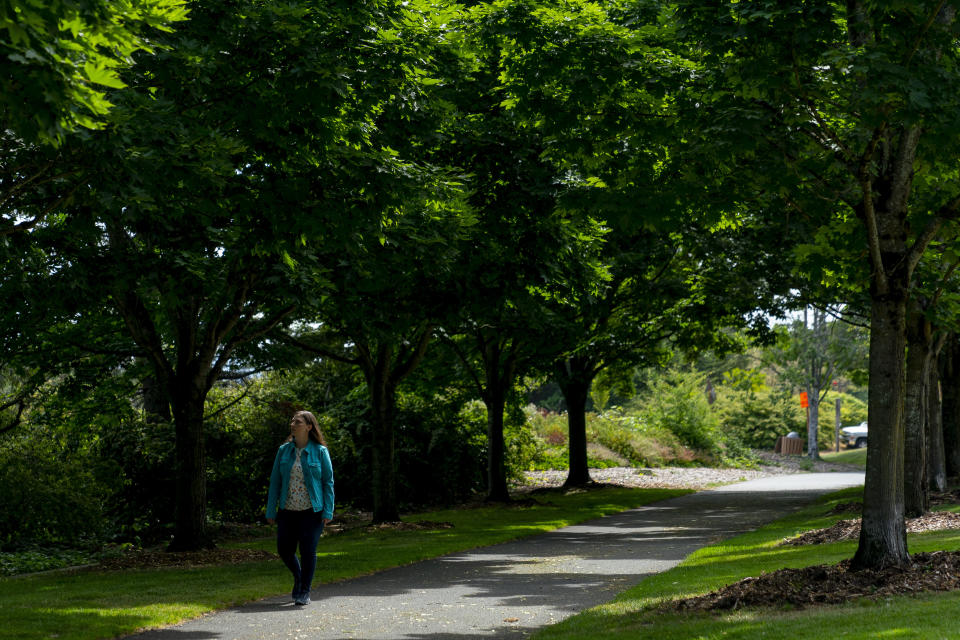 Jamie Crase, who participated in a phase 1 ovarian cancer vaccine trial 11 years ago, walks on a path near her home, Wednesday, June 7, 2023, in Mercer Island, Wash. While she doesn't know whether the vaccine helped, Crase is now 50 with no signs of cancer. (AP Photo/Lindsey Wasson)