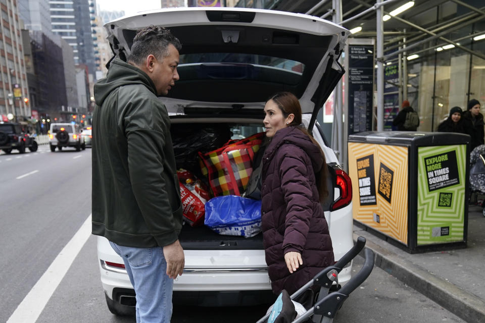 Mayra Martinez, right, of Colombia, and her partner pack their belongings into a car after leaving the Row Hotel , Tuesday, Jan. 9, 2024, in New York. (AP Photo/Mary Altaffer)