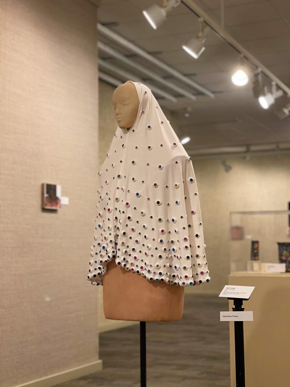 Amal Azzam won third prize for her mixed media work 'All Eyes on Me' in Rahr-West Art Museum's juried exhibition 'Being: A Recognition of Self and Other.'