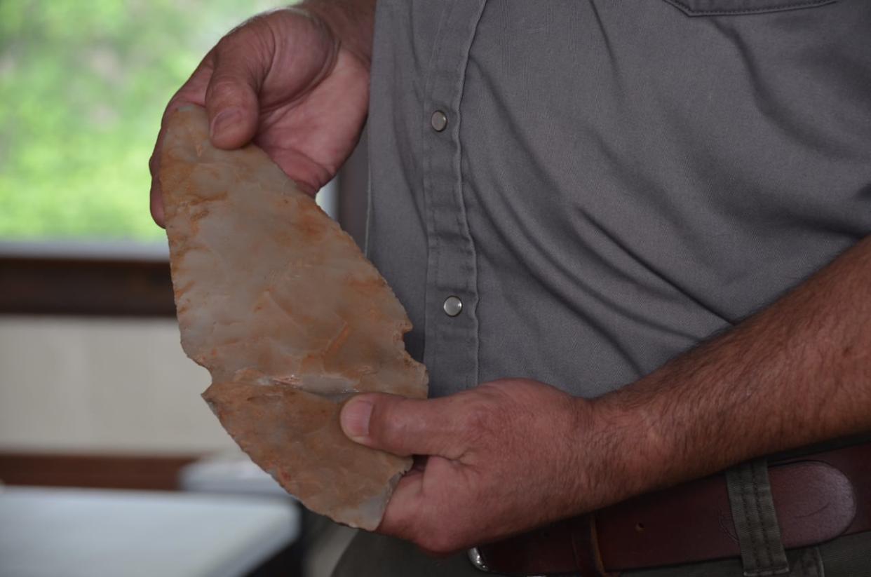 Archeologist Ryan Primrose holds a ceremonial tool that was never meant to be used that he found in a cache of other artifacts in the Temiskaming district dating back 3,100 years.  (Erik White/CBC - image credit)