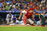 Philadelphia Phillies catcher J.T. Realmuto, right, gets the throw as New York Mets' Starling Marte, left, steals home during the fifth inning of a baseball game, Friday, Aug. 19, 2022, in Philadelphia. (AP Photo/Chris Szagola)