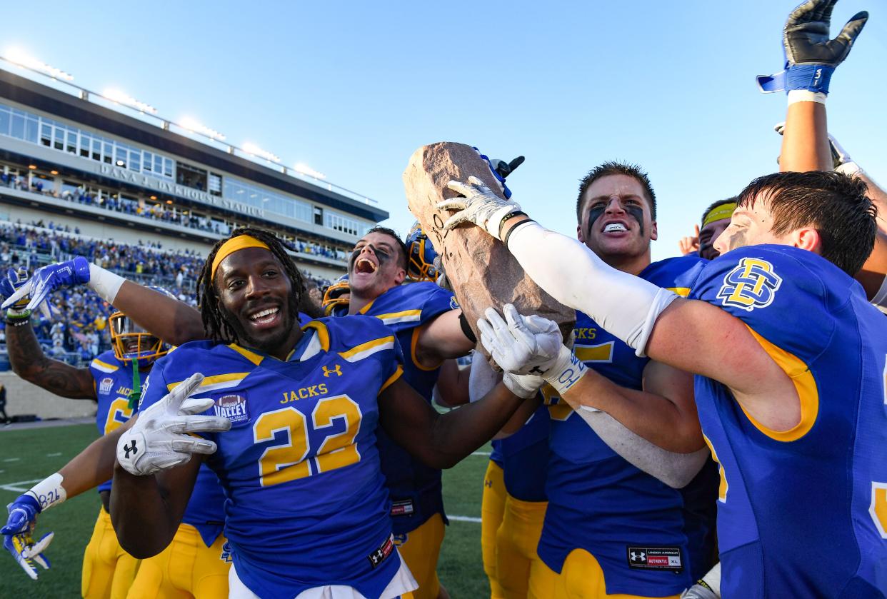 South Dakota State players grab the Dakota Marker trophy after winning the annual game against North Dakota State on Saturday, November 6, 2021 at Dana J. Dykhouse Stadium in Brookings.