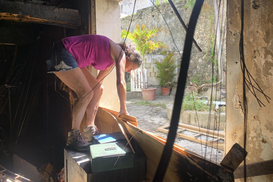 Emilie shows how she escaped her home during a fire after riots in Pointe-a-Pitre, Guadeloupe island, Sunday, Nov.21, 2021. French authorities are sending police special forces to the Caribbean island of Guadeloupe, an overseas territory of France, as protests over COVID-19 restrictions erupted into rioting. In Pointe-a-Pitre, the island's largest urban area, clashes left three people injured, including a 80-year-old woman who was hit by a bullet while on her balcony. A firefighter and a police officer were also injured and several shops were looted there and in other towns. (AP Photo/Elodie Soupama)