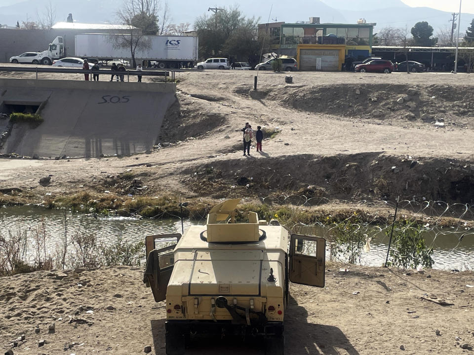 Texas National Guard troops patrol the Border in El Paso, Texas, as migrants watch from across the river in Ciudad Juárez, Mexico on Tuesday, Dec. 20, 2022. About 400 troops arrived early Tuesday morning to secure the border with Humvees and concertina wire. (AP Photo/Giovanna Dell’Orto)