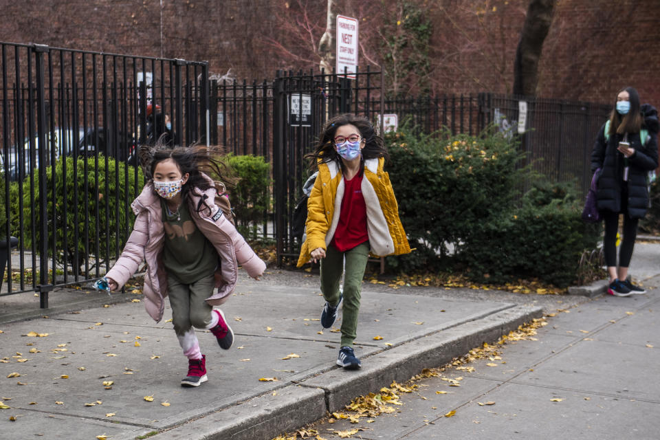 Students wearing masks leave the New Explorations into Science, Technology and Math (NEST+m) school in the Lower East Side neighborhood of Manhattan on Tuesday, Dec. 21, 2021, in New York. (AP Photo/Brittainy Newman)