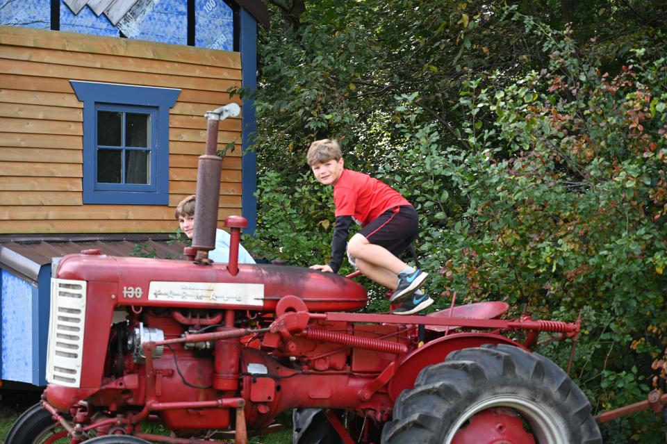 Children play on top of farming tractor at Medway Community Farm's 2021 Fall Festival.