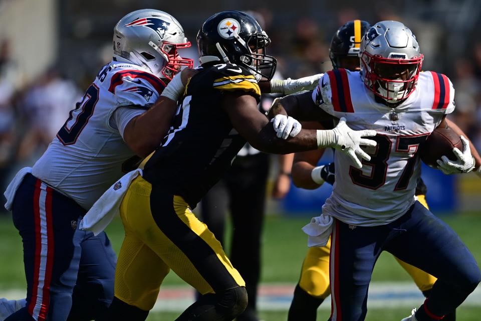 Patriots running back Damien Harris, right, tries to break past Steelers linebacker Myles Jack during the fourth quarter on Sunday.